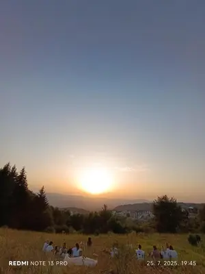 a group of people in a field at sunset at President Kop Apartman 106 in Kopaonik
