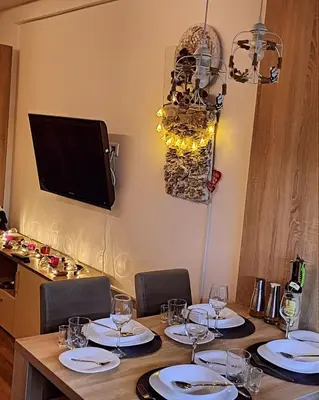 a table with chairs and a television on a wall at President Kop Apartman 106 in Kopaonik
