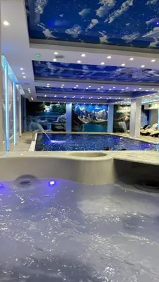 a large pool of water in a room with blue ceilings at President Kop Apartman 106 in Kopaonik