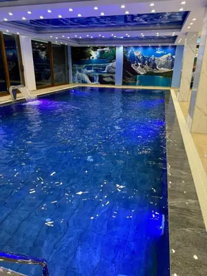 a swimming pool in a hotel with blue water at President Kop Apartman 106 in Kopaonik