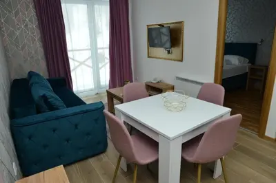 a living room with a white table and a blue couch at Kraljevi Cardaci Cardak in Kopaonik