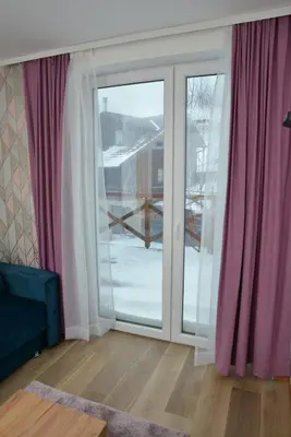 a room with a sliding glass door with pink curtains at Kraljevi Cardaci Cardak in Kopaonik