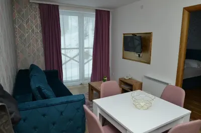 a living room with a blue couch and a table at Kraljevi Cardaci Cardak in Kopaonik