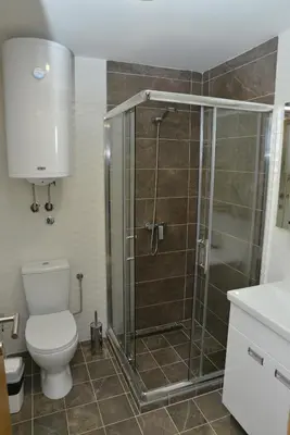 a bathroom with a toilet and a glass shower at Kraljevi Cardaci Cardak in Kopaonik