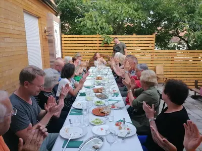 a group of people sitting at a long table eating food at A Bre Da Bre Family Club in Niš
