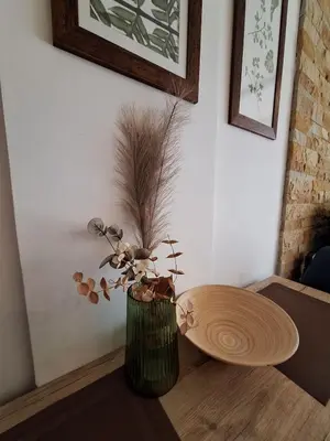 a vase with a plant in it on a table at Apartmani L6 & P90 Milmari Kopaonik in Kopaonik