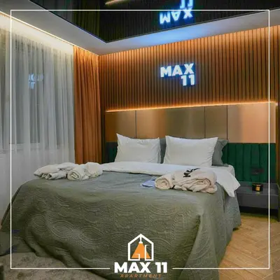 a master bedroom with a large bed with towels on it at MAX 11 Apartman in Kruševac