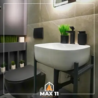 a bathroom with a white sink and a toilet at MAX 11 Apartman in Kruševac