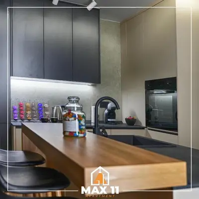 a kitchen with black cabinets and a counter top at MAX 11 Apartman in Kruševac