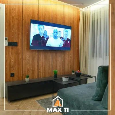 a living room with a tv on a wooden wall at MAX 11 Apartman in Kruševac