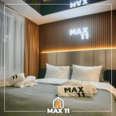 a bedroom with a large bed with two pillows on it at MAX 11 Apartman in Kruševac
