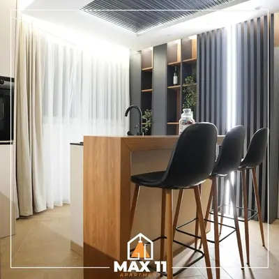 a kitchen with a table and chairs in a room at MAX 11 Apartman in Kruševac