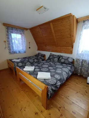 a bedroom with a bed and a wooden floor at Vila Milica Apartmani in Kopaonik