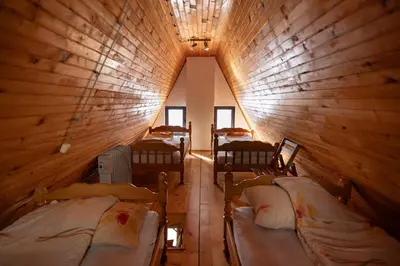 a room with four beds in a wooden cabin at Vila Milica Apartmani in Kopaonik