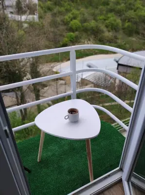 a cup of coffee sitting on a table on a balcony at Apartman GreenPine in Soko Banja