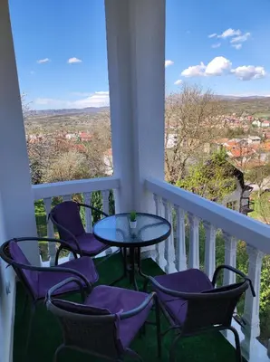 a table and chairs on a balcony with a view at Apartman GreenPine in Soko Banja