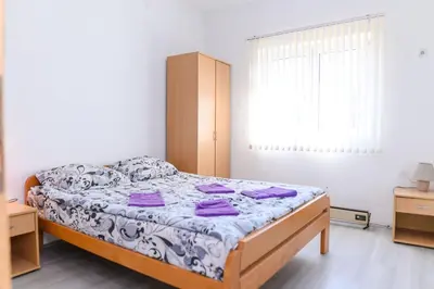 a bedroom with a bed with purple sheets at Apartmani Merlin in Soko Banja