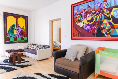 a living room with a couch and a painting on the wall at Apartmani Merlin in Soko Banja