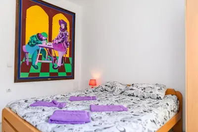 a bed in a room with a painting on the wall at Apartmani Merlin in Soko Banja