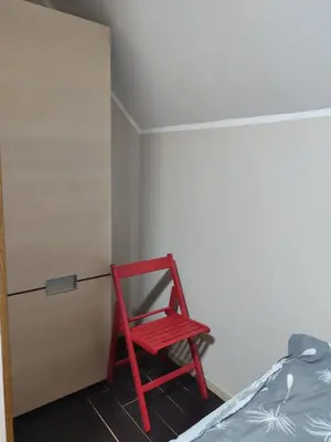 a red chair sitting in a room next to a bed at WEGA Star Apartmani in Brzeće