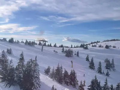 a snow covered slope with trees and a ski lift at WEGA Star Apartmani in Brzeće