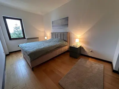 a bedroom with a bed and a window and two lamps at Glecer A07 in Kopaonik
