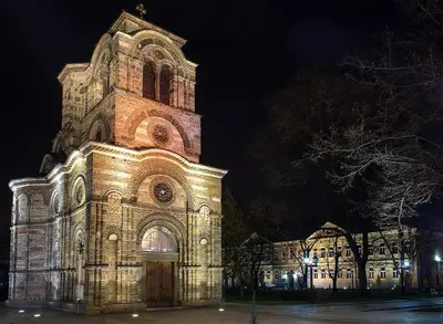 a large building with a clock tower at night at Studio apartman Nataly in Kruševac
