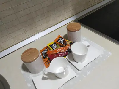 a counter with two cups and snacks on a table at Studio apartman Nataly in Kruševac
