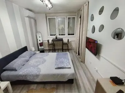 a bedroom with a bed and a dining room at Studio apartman Nataly in Kruševac