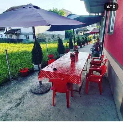 a red table with red chairs and an umbrella at Apartmani MiS apartman br 2 in Soko Banja