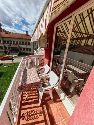 a balcony with a table and chairs on a building at Apartmani MiS apartman br 2 in Soko Banja