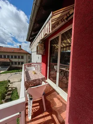a pink building with a table and a chair on a porch at Apartmani MiS apartman br 2 in Soko Banja