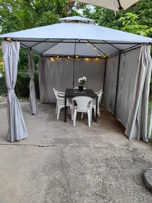 a tent with a table and chairs under it at Apartmani MiS apartman br 2 in Soko Banja