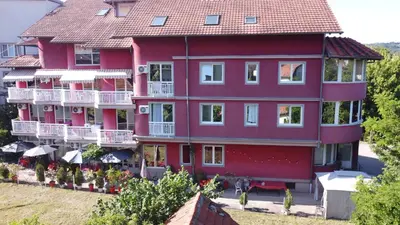 a large red building with white balconies at Apartmani MiS apartman br 2 in Soko Banja