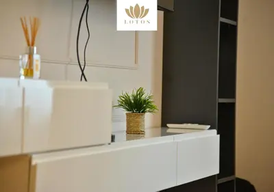 a white cabinet with a plant on top of it at Lotos Apartments in Kruševac