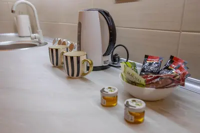 a counter with a coffee maker and cups on it at Lotos Apartments in Kruševac