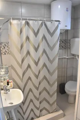 a bathroom with a shower curtain and a sink at BeLux apartment in Niš