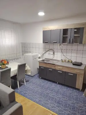 a kitchen with a sink and a refrigerator and a table at Fili 1 in Ćuprija