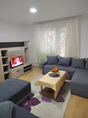 a living room with a blue couch and a tv at Fili 1 in Ćuprija