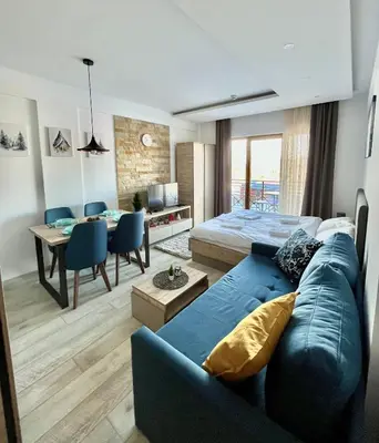 a living room with a blue couch and a bed at ICE-KOP Milmari in Kopaonik
