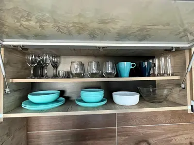 a cupboard with bowls and plates and glasses at ICE-KOP Milmari in Kopaonik
