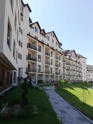 an apartment building with a lawn in front of it at ICE-KOP Milmari in Kopaonik