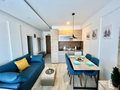 a living room with a blue couch and a table at ICE-KOP Milmari in Kopaonik