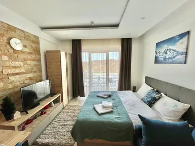 a hotel room with a bed and a television at ICE-KOP Milmari in Kopaonik
