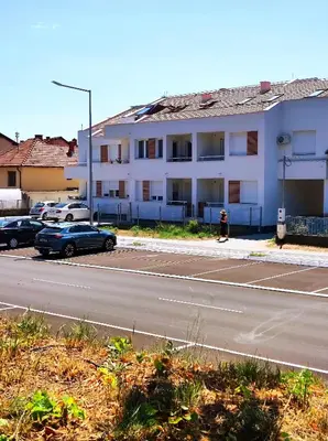 a parking lot with cars parked in front of a building at Riverside LUX Apartment in Pirot