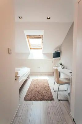 an attic bedroom with a desk and a window at Hotel Dijana in Pirot