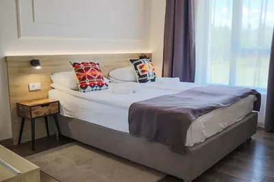 a large bed with pillows on it in a room at Hotel Dijana in Pirot