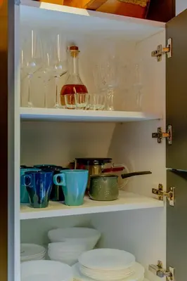 a cabinet filled with glasses and plates and bowls at Viktorija chalet in Kopaonik