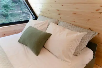a bed with four pillows in a tiny house at Viktorija chalet in Kopaonik