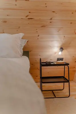 a bedroom with a bed and a table with a lamp at Viktorija chalet in Kopaonik
